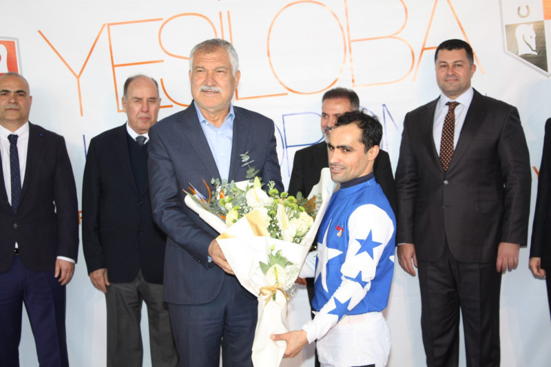 Törende Adana Büyükşehir Belediye Başkanı Zeydan Karalar kazanan safkanın jokeyine günün anısına hediyesini ve çiçeğini takdim etti.